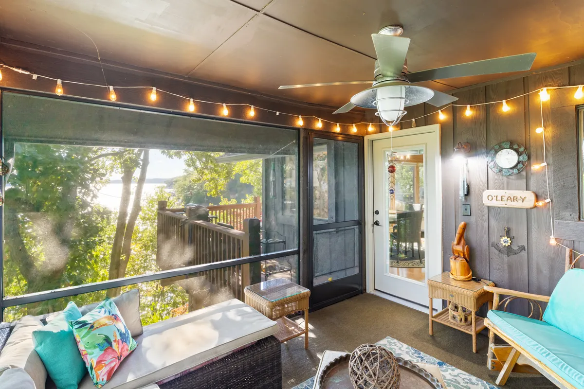 A screened patio with comfortable seating, string lights overhead, and views through the screens to the outdoors. The ambiance is cozy and welcoming, ideal for relaxed mornings or sunset gatherings.
